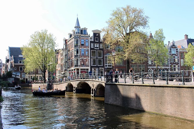 Amsterdam Canal Tour by Open Boat – 90 min Small Group Experience - Munt Tower and the iconic spires you remember later