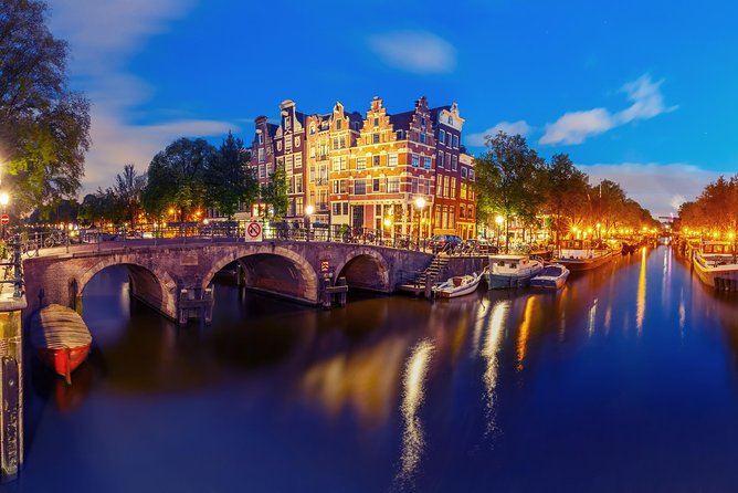 Amsterdam Evening Canal Cruise with Live Guide and Onboard Bar - Magere Brug, Munttoren, and the Amstel origin story