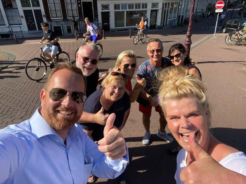 Amsterdam: Kultour, Kulturelle Stadtführung mit Herz & Seele - Meeting at Beursplein, Damrak, and finding your black-and-white striped guide