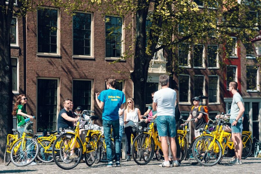 Amsterdam: Relaxed City Highlights Guided Bike Tour - Canal belt 101: 17th-century houses, the smallest-house challenge, and a hidden prison story