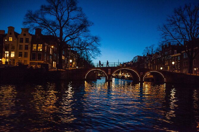 Evening Canal Cruise in Amsterdam with Wine & Cheese Option - Westerkerk and Amsterdam Centraal at night: two very different landmark moods